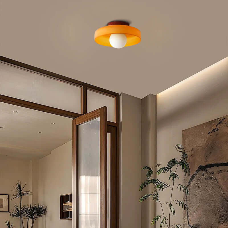 modern round ceiling light in dining area, orange metal glass